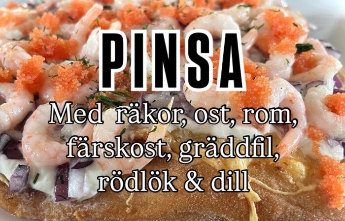 Pinsa med räkor, ost, rom, färskost, gräddfil, rödlök och dill toppad med dekorativa detaljer.