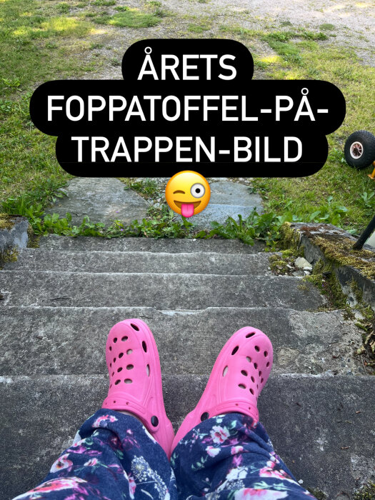 Person sitter på trappa med rosa plasttofflor och blommiga byxor, med texten "Årets foppatoffel-på-trappen-bild" och ett lekfullt emoji.