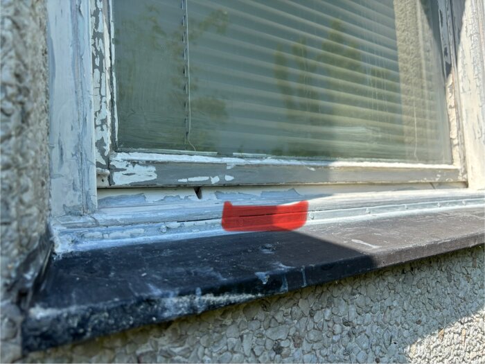 Äldre tvåglasfönster med spricka mellan träkarm och metallbleck markerad med rött. Fråga om tätning med latex eller silikon.