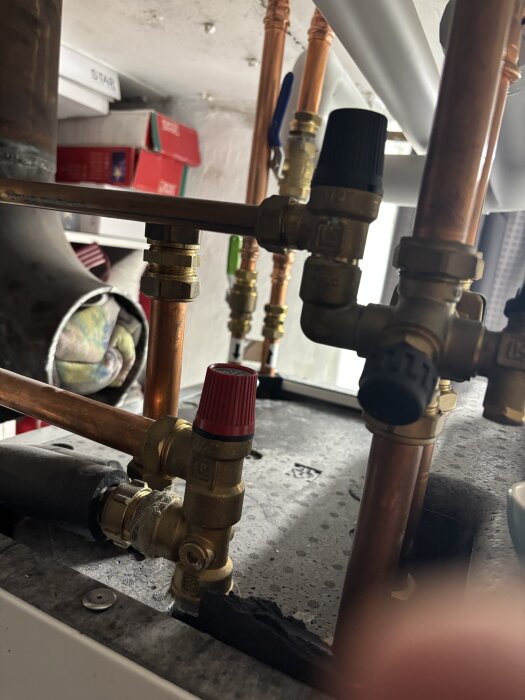 Rörsystem med två ventiler, en röd och en svart. Den röda är justerad, den svarta är en säkerhetsventil för inkommande vatten.