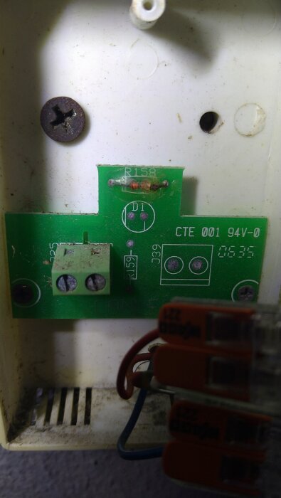 Grön kretskort i en plastkapsling med kablar ansluten till terminal. Märkt med CTE 001 94V-0 och R158.
