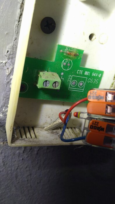 Närbild på kopplingsplint och kretskort, del av en värmepumpsinstallation. Visa anslutna kablar och komponenter.