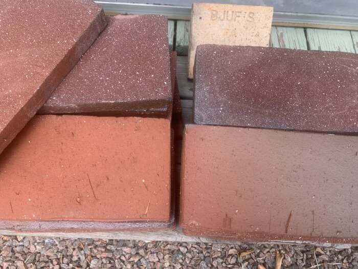 Bruna och röda Höganäs klinkers staplade på varandra, visa olika nyanser och texturen av plattorna.
