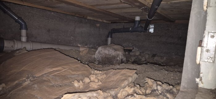 Krypgrund med stenar och rör, stor sten synlig, delvis röjd från skräp och sten.