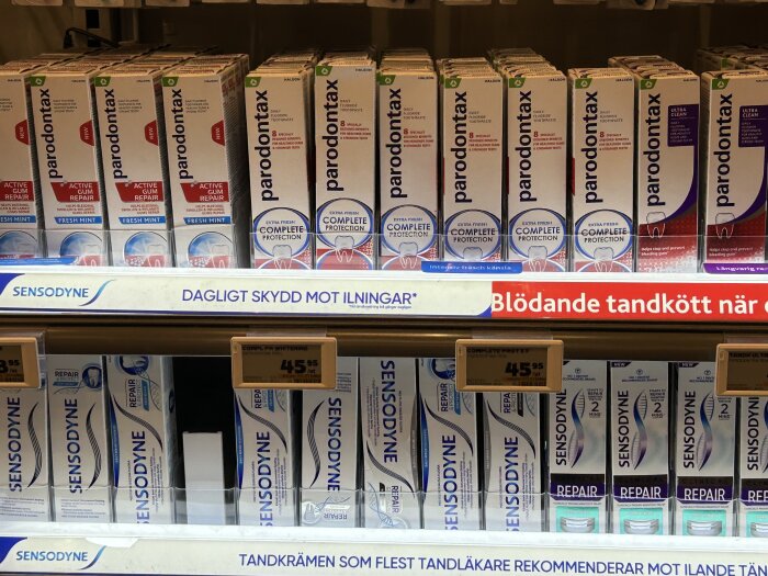 Tandkrämshyllor i butik med flera rader av Parodontax och Sensodyne-förpackningar. Vissa förpackningar är utan kartong.