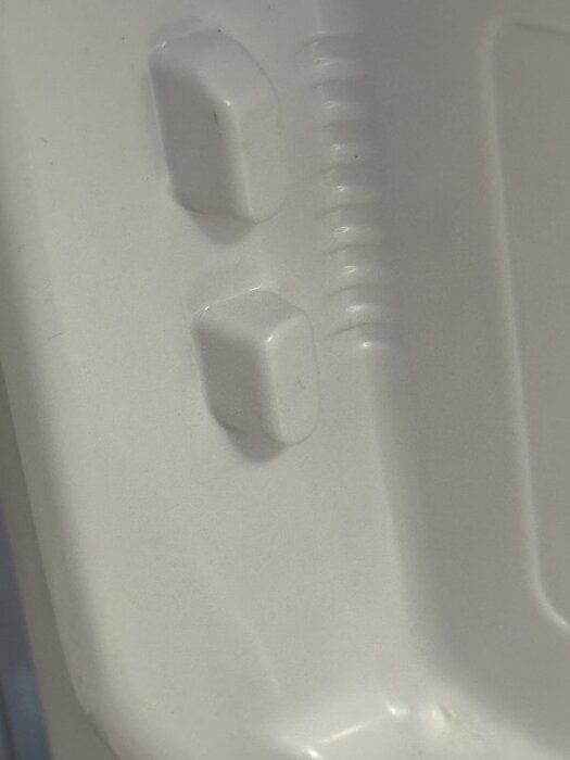 Närbild av trasigt hyllfäste inuti ett kylskåp från Electrolux, visar kvarvarande del av hyllans anslutning på dörrens insida.