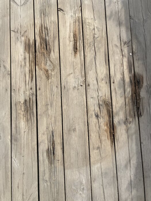 Slitna träplankor med synliga skador och tecken på åldrande.