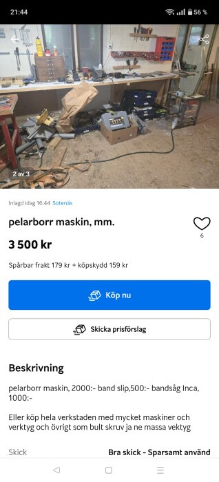 Verkstad med arbetsbänk fylld av verktyg och material, pelarborr maskin i kartong, samt diverse maskiner och verktyg organiserade på hyllor och i lådor.