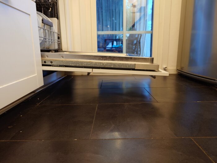 Bild av en Ikea "Välgjord" diskmaskinslucka som lutar nedåt i öppet läge, vilket visar ett potentiellt gångjärnsproblem.