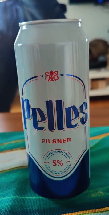 En burk öl med etiketten "Pelles Pilsner", står på ett bord.