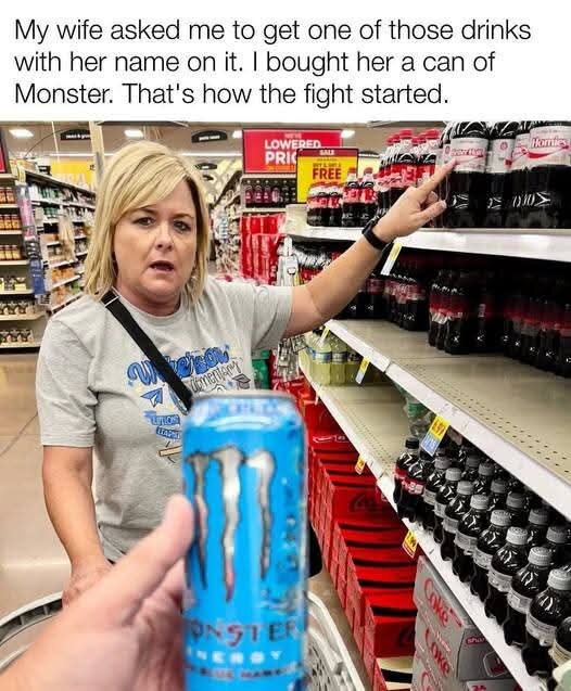 En kvinna i en butik pekar på en hylla med Coca-Cola-flaskor medan en person håller en Monster-energidryck framför kameran.