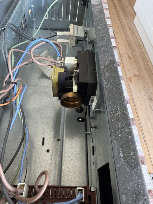 Inuti ugnen med synliga kablar och urverk; fråga om hur man kopplar bort urverket för att stoppa oljud.