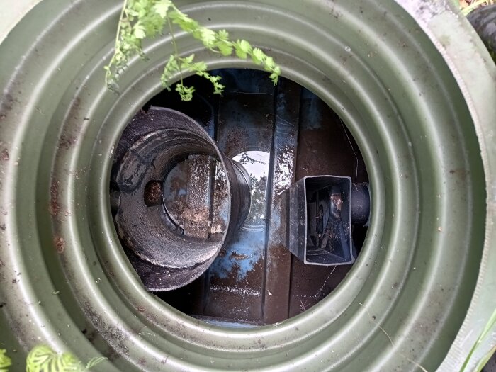 Öppning på Fann slamavskiljare, visar insidan med vatten och ventiler.