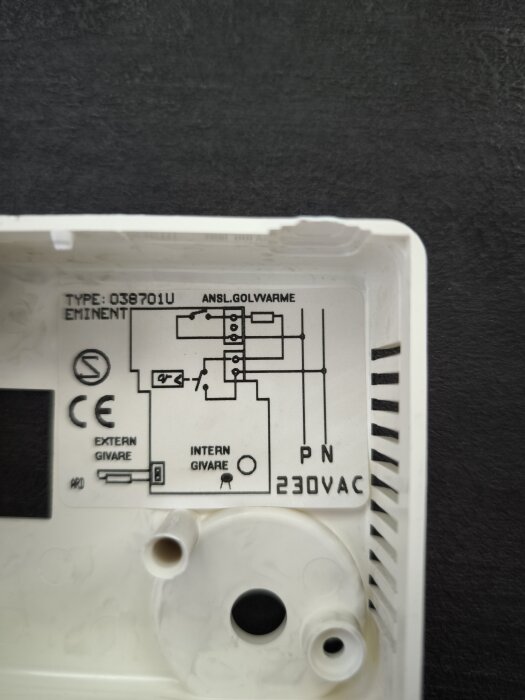 Ritning och specifikationer på insidan av ett värmeregleringssystem, med text om anslutning av golvvärme och spänning på 230V AC.