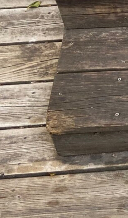 Slitet trätrappa med missfärgat och skadat trä.