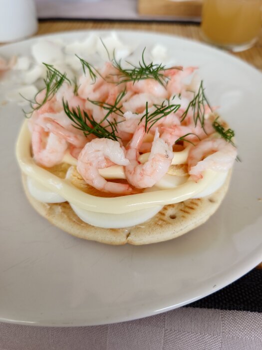 Räksmörgås med ägg och dill på en tallrik.