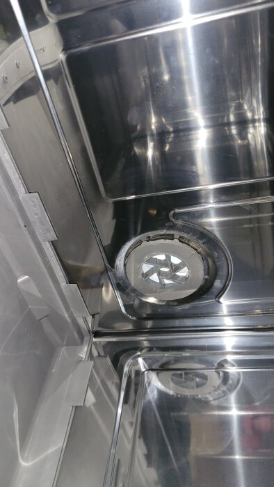 Grå plastgenomföring fast i påfyllningskassett av rostfritt stål.