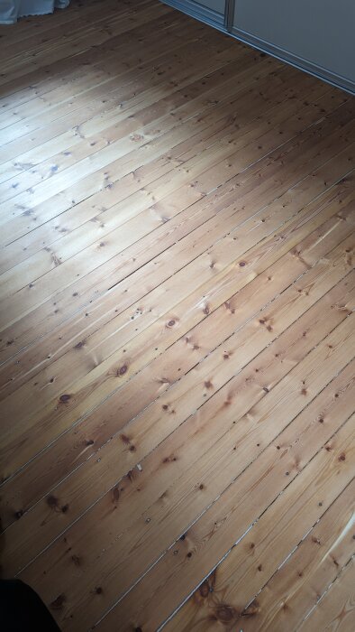 Nyslipat trägolv behandlat med naturolja, något för mörkt och rödaktigt enligt ägaren, som överväger ytterligare behandling för ljusare ton.