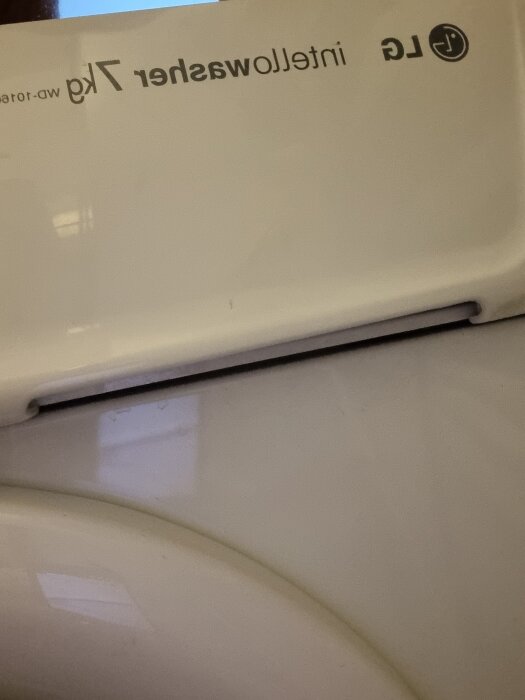 Tvättmaskin av märket LG intellowasher 7 kg sedd från sidan, texten syns uppochner.