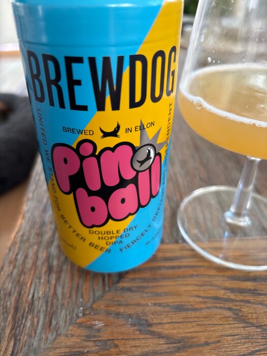 Brewdog Pinball ölburk och vinglas på träbord.