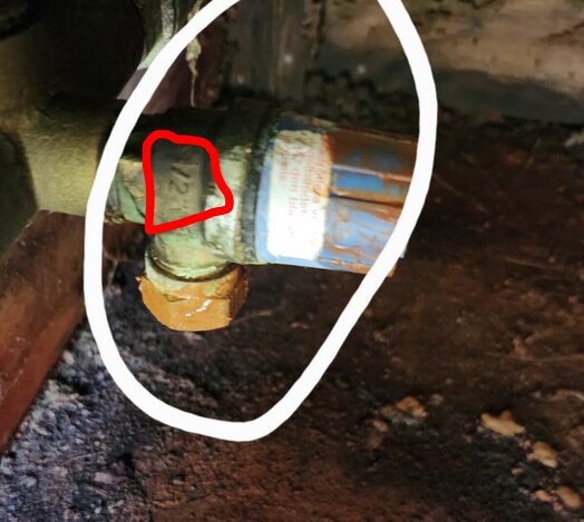 Säkerhetsventil kopplad till en vattenpump, markerad i rött, anger dimension 1/2" och tryck på 6 bar, omgiven av rost och smuts.