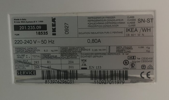 Etikett med teknisk data för en IKEA integrerad kyl och frys, modell CB304W, visar strömförbrukning och kapacitet i liter samt serienummer.
