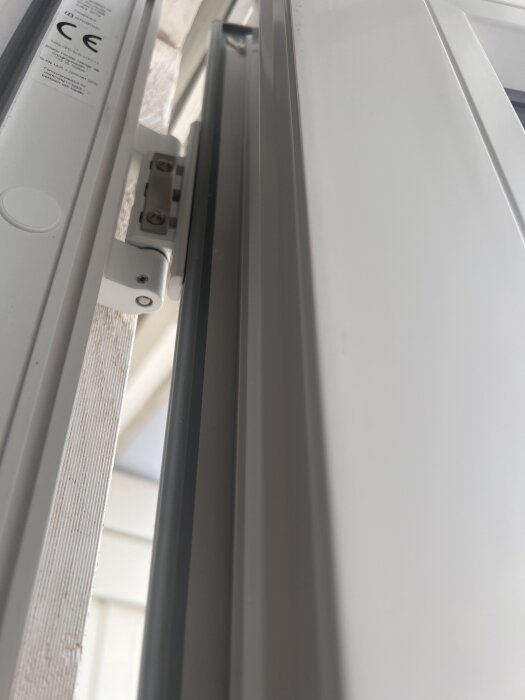 Gångjärn på altandörrens karm, visar skruvar och dörrens justering.