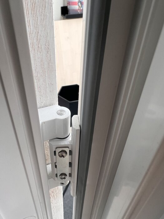 Gångjärn på altandörr, närbild på dörrkarmen med synliga justeringsskruvar.