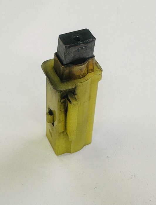 Kolborste för dammsugarmotor på vit bakgrund, del av reparation av spånsug för att förbättra sugkraft i verkstadsprojekt.