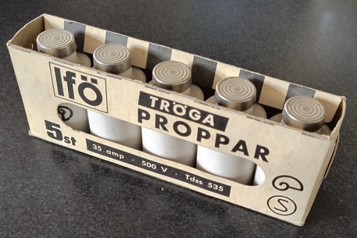 Förpackning med fem äldre vita proppsäkringar av märket Ifö, märkta med 35 amp, 500 V.