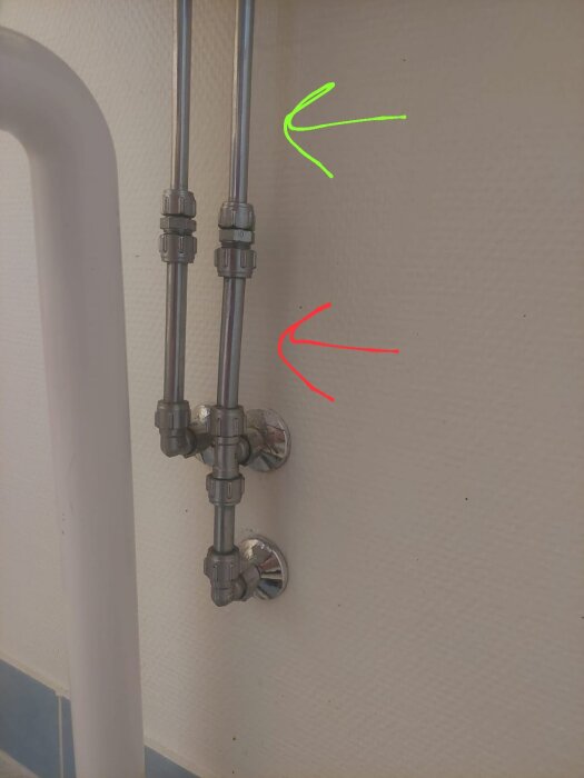 Rör och kopplingar monterade på vägg, markerade med gröna och röda pilar för att visa storlekar på 12 mm och 10 mm.