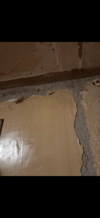 Klassisk murstocksvägg från 1967 med delvis avskavd färg och synlig struktur, potentiell asbestrisk i beklädnadens utseende.