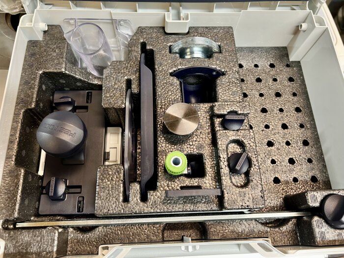 Låda med frästillbehör, inklusive knoppar och fästen, inbäddade i skum.