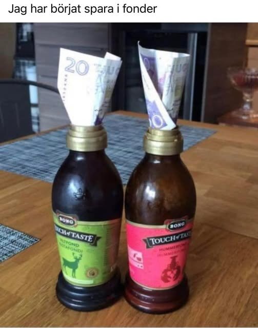 Två flaskor med fond, var och en med en hoprullad sedel i toppen, står på ett bord.