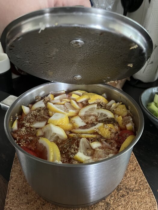 Kastrull med jordgubbar och citronskivor under lock, inspirerad safttillredning.