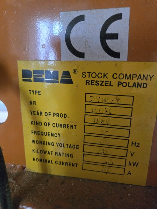 Etikett på maskin från REMA, Polen, med tekniska specifikationer som typ, årsmodell och spänning. CE-märkning synlig högst upp.
