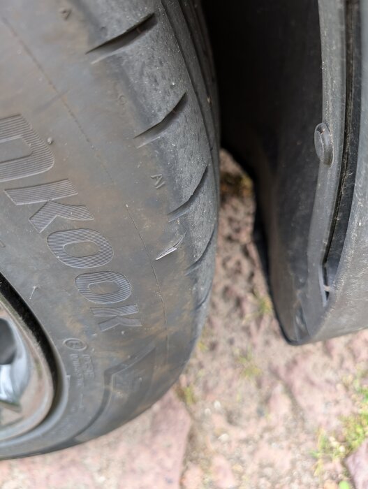 Ett slitet och skadat däck på ett fordon, visar tecken på skada eller slitage.