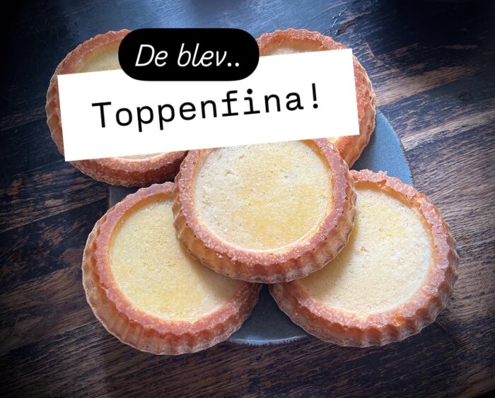 Fem gyllene tartletter med texten "De blev.. Toppenfina!" på en mörk träyta.