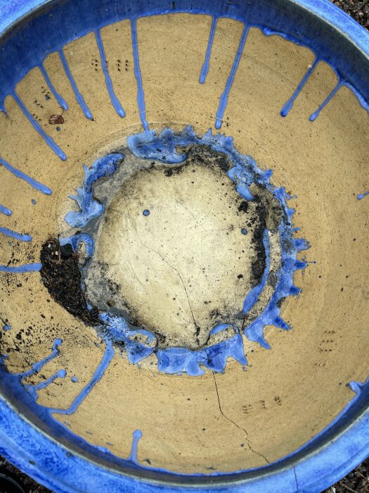 Stor keramikkruka med blå glasyr och synliga sprickor inuti.