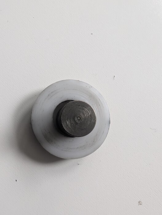 Hjul för skjutdörr i stål och plast, ca 25mm diameter, 10mm axel. Placerad mot en vit bakgrund.