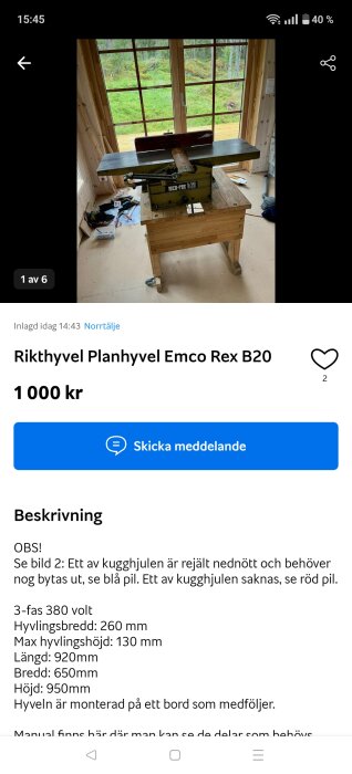 En rikthyvel Emco Rex B20 monterad på ett träbord, placerad framför ett stort fönster med utsikt över en grönskande skog.
