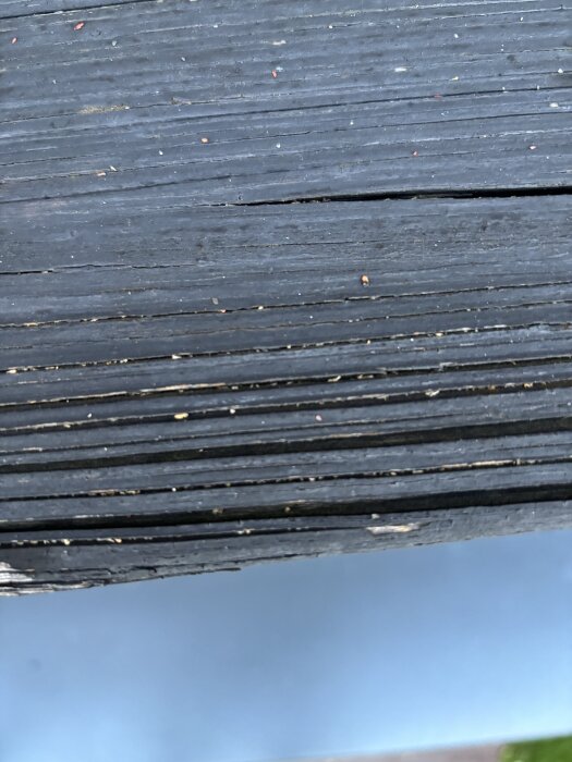 Solskadat trästaket med skador och missfärgningar, potentiell ytbehandling diskuteras innan målning.