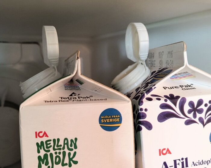 Öppnade mjölkkartonger i kylskåp med korkarna uppåt.