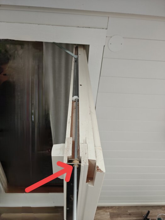 Öppnat fönster med en justerbar stång och en röd pil som pekar på en plats där stången kan behöva kapas.