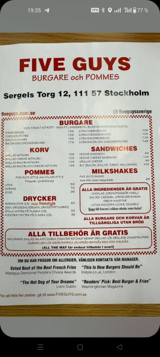 Meny från Five Guys på Sergels Torg 12, Stockholm, med priser på burgare, korv, pommes frites, dryck och milkshakes.