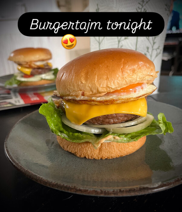 Grillad hamburgare med nötkött, bröd, stekt ägg, ost, sallad, tomat, lök och dressing på en tallrik.