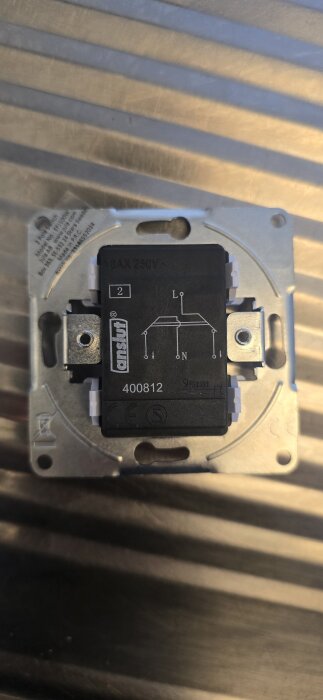 Elektrisk komponent med texten "16AX 250V" och "anslut", samt anslutningsschema med L och N.