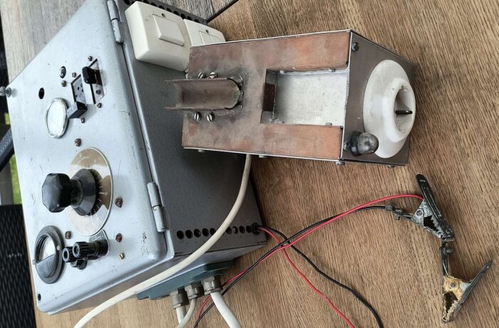 Gammal elektronisk apparat med rattar, mätare och sladdar, troligen använd för okänd funktion i ett 50-tals hobbyrum.