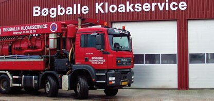 Röd lastbil med texten "Bøgballe Kloakservice" parkerad framför en byggnad med samma namn.