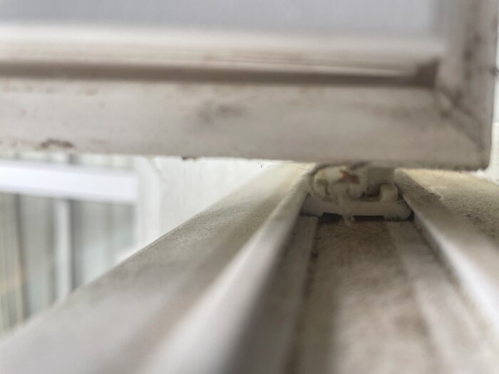 Gliddelen för ett Myresöfönster från 1993, fotograferad från sidan i närbild, med smuts och damm synligt på ytan.